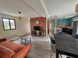 a living room with a couch and a table at Maison de la Butte de Thil in Nan-sous-Thil