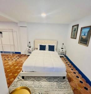 a white bed in a room with two tables at Elegant 1BR Montrose - Napoli The Italian Plaza in Houston