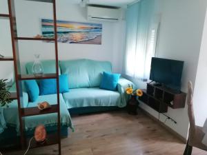 a living room with a blue couch and a television at Casa Paraiso in Almería