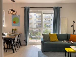 a living room with a green couch and a table at URBAN APARTMENTS PREMIUM Baildona No 11 FREE GARAGE, Self CHECK-IN in Katowice