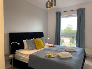 a bedroom with a bed with towels and a window at URBAN APARTMENTS PREMIUM Baildona No 11 FREE GARAGE, Self CHECK-IN in Katowice