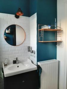 ein Badezimmer mit Waschbecken und Spiegel in der Unterkunft chambre dans maison place du commando, bord de mer in Saint-Nazaire