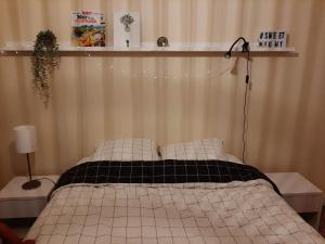 ein Schlafzimmer mit einem Bett mit einer schwarzen und weißen Decke in der Unterkunft chambre dans maison place du commando, bord de mer in Saint-Nazaire