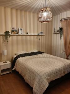 ein Schlafzimmer mit einem Bett und einem Kronleuchter in der Unterkunft chambre dans maison place du commando, bord de mer in Saint-Nazaire