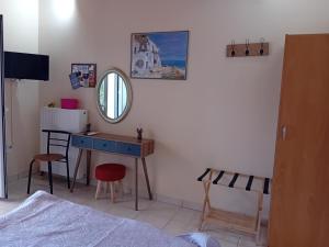 a bedroom with a desk and a mirror and a bed at Valta's Room 2 in Paleros