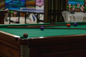 three pool balls on a green pool table at HANNA San Diego Apart Hotel in Florianópolis