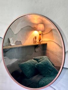 a round mirror with a chair and a lamp on a shelf at Casa Villa María, Recién Remodelada in Villa de Leyva