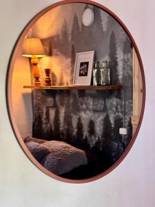 a mirror hanging on a wall with a lamp on a shelf at Casa Villa María, Recién Remodelada in Villa de Leyva