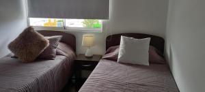 a bedroom with two beds and a table with a lamp at Matiz 01 in Iquique