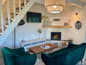 a living room with two green chairs and a table at Tajemnicza Kraina in Wetlina