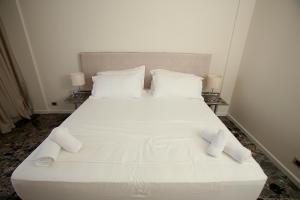 un letto bianco con due cuscini sopra di Durres Bay Hotel a Durrës