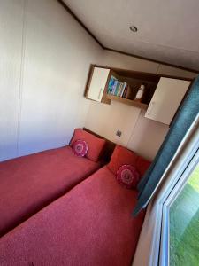 a living room with a red couch and a window at Tattershall Lakes in Tattershall +7 photos