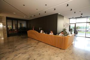 due persone sedute a un bancone in una hall di Durres Bay Hotel a Durrës Altre 37 foto