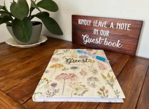 ein Buch, das auf einem Holzboden neben einem Schild liegt in der Unterkunft Verdiend En-suite Unit at Ngweni Private Game Farm in Hluhluwe