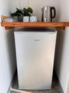 ein weißer Kühlschrank mit einem Holzregal darauf in der Unterkunft Verdiend En-suite Unit at Ngweni Private Game Farm in Hluhluwe