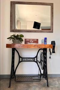 ein Tisch mit einem Spiegel und einer Pflanze darauf in der Unterkunft Verdiend En-suite Unit at Ngweni Private Game Farm in Hluhluwe