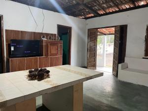 una cucina con un tavolo con una TV e un piano di lavoro di Casa temporada frente ao mar , ilheus-ba a Ilhéus