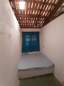 un piccolo letto in una stanza con una finestra di Casa temporada frente ao mar , ilheus-ba a Ilhéus