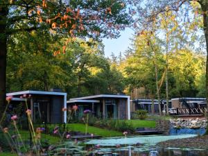 a house in a garden with a pond at Stylish Stay Near Veluwe in Hoenderloo