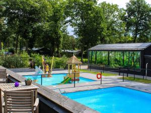 a swimming pool with a playground and a gazebo at Stylish Stay Near Veluwe in Hoenderloo