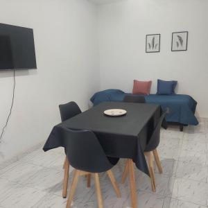 ein Zimmer mit einem Tisch und Stühlen und einem Bett in der Unterkunft Departamentos Falucho 3 in Santa Rosa