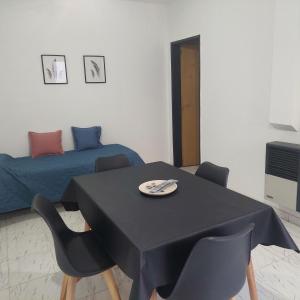 ein Zimmer mit einem Tisch und Stühlen und einem Bett in der Unterkunft Departamentos Falucho 3 in Santa Rosa