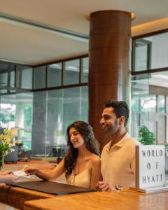 a man and woman sitting at a table with a laptop at Hyatt Pune in Pune