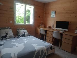 a bedroom with a bed and a desk and a computer at Maison Cosy Lac d'Annecy in Talloires