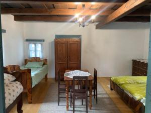 a room with a table and a bed and a table and chairs at Biró vendégház in Sărăţeni