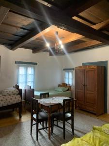 a room with a table and chairs and a bedroom at Biró vendégház in Sărăţeni