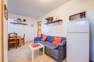 a living room with a blue couch and a refrigerator at La Tana Dell'Ermellino 3 Ski In Ski Out - Happy Rentals in Sestriere