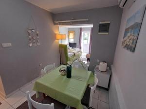 a dining room with a green table and chairs at Apartmani Župa in Tivat