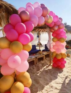 a bunch of pink and yellow balloons on the beach at Tiba soliman plage in Nabeul