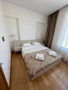 a bedroom with a bed with two towels on it at Seabreeze apartments Budva in Budva +11 photos