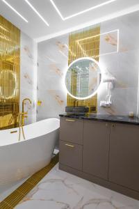 a bathroom with a tub and a sink and a mirror at Allure GALAXY Centrum Aparthotel in Szczecin +78 photos