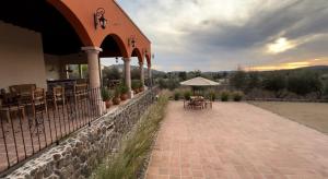 un edificio con un patio con mesas y una sombrilla en Hacienda Maria Trinidad, en Valle de Guadalupe