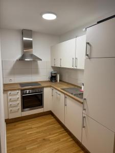 a kitchen with white cabinets and a stainless steel refrigerator at Barrierefreie Wohnung im Herzen der Stadt mit Parkplatz, Wifi und TV - Emma in Werne