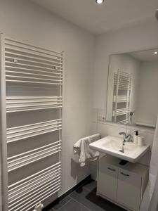 a white bathroom with a sink and a mirror at Barrierefreie Wohnung im Herzen der Stadt mit Parkplatz, Wifi und TV - Emma in Werne +23 photos