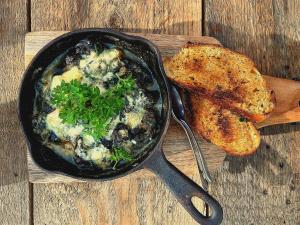 a cast iron skillet with a dish of food and bread at 300m2 greenhouse in Jälist