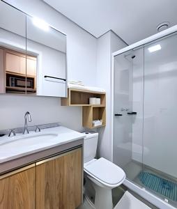 a bathroom with a toilet and a sink and a shower at Apto com piscina aquecida e rooftop in Curitiba