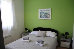 Un dormitorio verde con una cama con toallas. en Casa Ondina - Istrian traditional house, en Šumber