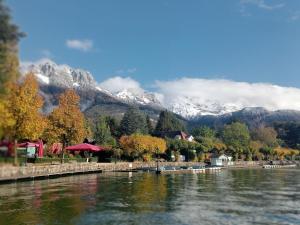 a bridge over a lake with mountains in the background at Maison Cosy Lac d'Annecy in Talloires