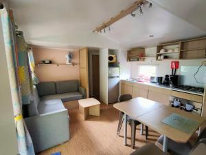 a small kitchen and dining room with a table in a caravan at Nat & Mayou in Onzain