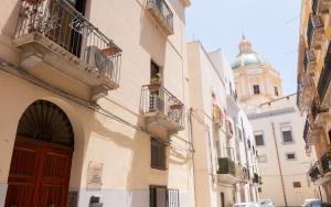 a building with a red door and a clock tower at La Trinacria Rooms in Trapani