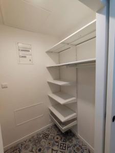 a white closet with empty shelves in a room at Studio calme à deux pas du lac de Nantua in Nantua +4 photos