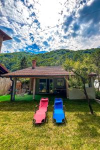 three chairs sitting in the yard of a house at Rivergreen in Banja Luka