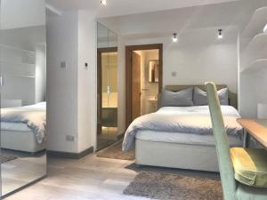 a bedroom with two beds and a mirror at Quiet Kensington flat ideal for central London in London