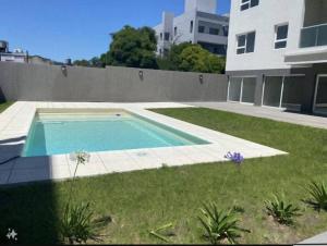 een zwembad in een tuin naast een gebouw bij Moderno 2 Ambientes con cochera in Tandil +4 foto's