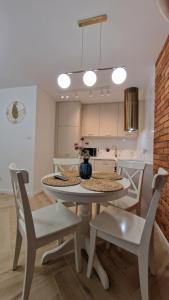 a kitchen with a table and chairs in a room at IMPRESJA apartament in Lublin