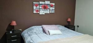 a bedroom with a bed with two lamps and two pictures at Casa con piscina y parque en Salta , zona aeropuerto in Salta